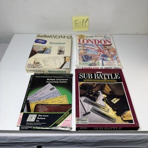 May include: Four vintage software boxes for Apple computers. Titles include BetterWorking Spreadsheet, Ticket to London, Multiple Checkbook Accounting System, and Sub Battle Simulator. Each box features colorful graphic illustrations and text.