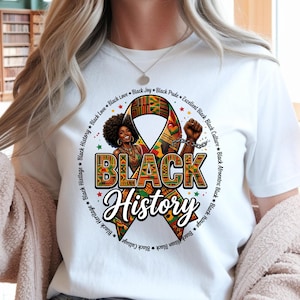 May include: White t-shirt featuring a colorful graphic celebrating Black History. The design includes a ribbon with the words "Black History" and a portrait of a woman with an afro. The design also includes the words "Black Love", "Black Joy", and "Black Pride".