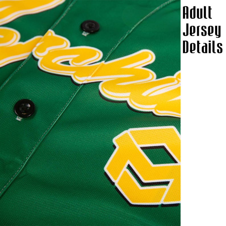 May include: Close-up of a green baseball jersey with yellow and white lettering and a logo. The jersey has black buttons and is made of a textured fabric. The text "Adult Jersey Details" is visible.