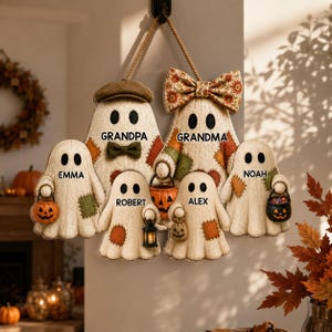 May include: A hanging wall decoration featuring six ghost figures with textured cream surfaces and colorful fabric patches. The ghosts are labeled Grandpa, Grandma, Emma, Robert, Alex, and Noah. They hold small pumpkin buckets and a lantern.