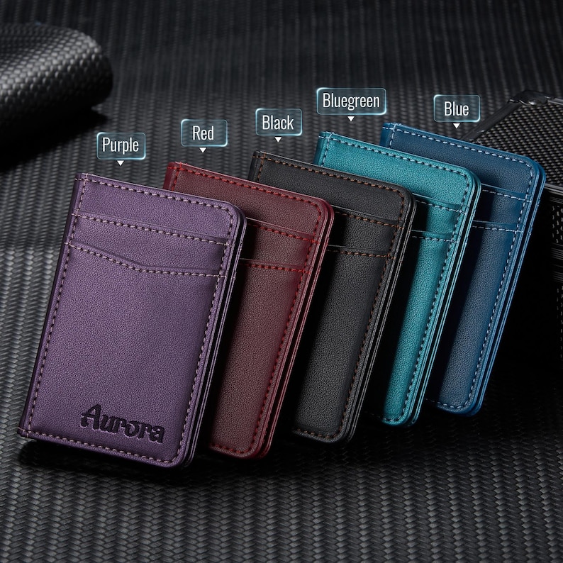 May include: A collection of leather cardholders in various colors: purple, red, black, bluegreen, and blue. Each cardholder has a pocket and is stitched around the edges. The word "Aurora" is embossed on the purple cardholder.