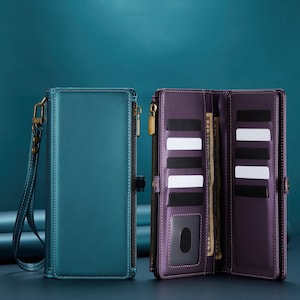 May include: Two leather wallets, one teal and one purple, are displayed against a teal background. The teal wallet is closed, with a wrist strap and a gold zip. The purple wallet is open, revealing card slots and a clear ID window.