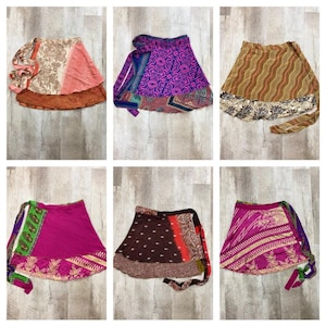 May include: Collection of six colorful wrap skirts. Each skirt features unique patterns and designs, including floral, geometric, and paisley motifs. The skirts showcase a variety of colors, such as pink, purple, brown, and green, with contrasting borders and ties.