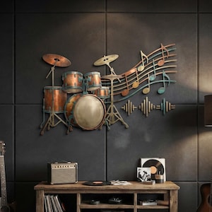 May include: A wall-mounted metal art piece depicting a drum kit with cymbals, connected to a flowing musical staff with notes and sound wave patterns. The sculpture features a weathered copper and bronze finish with teal accents throughout the design.