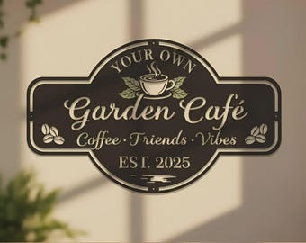 May include: A dark brown wooden sign with a cream-colored border and text. The sign reads "Your Own Garden Café" with a coffee cup graphic, and "Coffee, Friends, Vibes, Est. 2025". Decorative coffee beans are on each side.