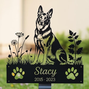 May include: Black metal garden stake with a German Shepherd silhouette. The stake has the name "Stacy" and the years "2015-2023", plus paw prints and plant cutouts. The dog is shown sitting with its tongue out.
