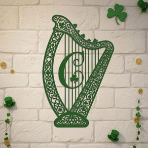 Puede incluir: Decoración de pared verde en forma de arpa con nudos celtas y detalles de tréboles. La letra "C" está en el centro del arpa. El fondo es una pared de ladrillos blancos, con tréboles, monedas de oro y sombreros verdes.