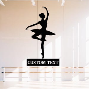 Puede incluir: Silueta negra de una bailarina en pose clásica, con tutú. La bailarina está en equilibrio sobre una pierna con los brazos elegantemente extendidos. Un rectángulo negro debajo dice "CUSTOM TEXT".