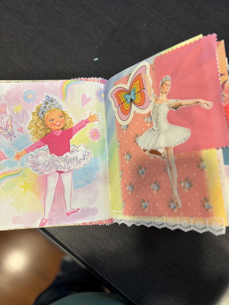 Pu&ograve; includere: Un diario fatto a mano con pagine con illustrazioni di ballerine e farfalle. Una pagina ha un disegno di una ballerina in un body e tut&ugrave; rosa. Un'altra pagina ha un adesivo di una ballerina in un tut&ugrave; bianco.