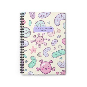 Könnte beinhalten: Spiralgebundenes Notizbuch mit cremefarbenem Einband, der mit Cartoon-Mikroben in Pastellfarben gemustert ist. Das Notizbuch trägt den Text "LAB NOTEBOOK 2026". Für den Einsatz im Labor konzipiert.