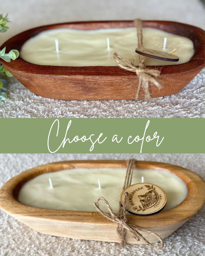 May include: A cream-coloured candle in an oval wooden bowl, with three wicks. A wooden tag is tied to the bowl with twine. The text "Choose a colour" is above the candle. The bowl is approximately 30 cm long.