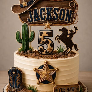Può includere: Un set di decorazioni per torta con un cappello da cowboy marrone, un cartello in legno con il nome JACKSON, un cactus verde, il numero 5 con motivo maculato, la sagoma di un cavaliere, una stella da sceriffo dorata e un cartello YEE-HAW.