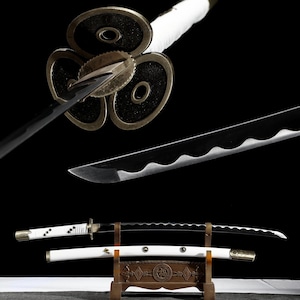 Puede incluir: Una espada katana japonesa con una hoja negra y un mango blanco. La espada presenta una guarda decorativa con un diseño floral y un soporte de madera. La hoja tiene un borde ondulado y se muestra sobre un fondo negro.