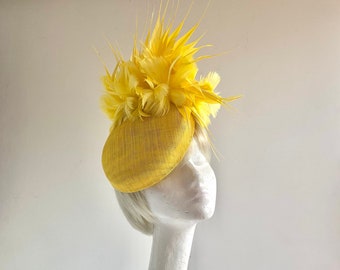 Bright yellow sinamay percher hat with many many ton sur ton feathers on comb