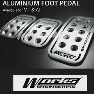 May include: Set of three aluminum foot pedals with a silver finish. The pedals have a rectangular shape with rounded edges and multiple circular holes. The text "ALUMINIUM FOOT PEDAL" and "Available for MT & AT" are at the top. The "Works Engineering" logo is at the bottom.