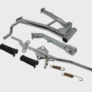 May include: A set of chrome-plated motorcycle parts including a center stand, a side stand, two black rubber foot pegs with a textured grip, and two metal tension springs. These components are designed for motorcycle maintenance and repair.