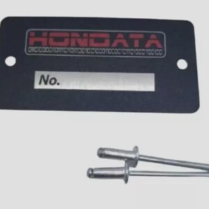 May include: A black rectangular plate with the word "HONDATA" in red, along with binary code. Below is a silver section with the word "No." and two silver rivets.