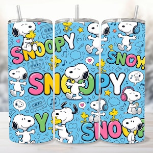 May include: A cylindrical tumbler with a light blue background featuring a repeating pattern of Snoopy and Woodstock characters, cassette tapes, musical notes, and stars. The word SNOOPY is printed in large, colourful, bubble-style letters.