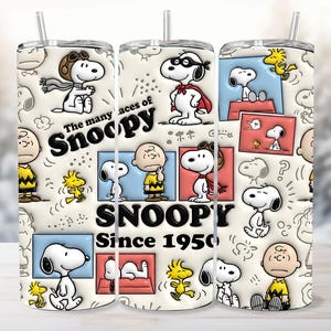 May include: A cylindrical tumbler featuring a repeating pattern of Snoopy and Woodstock characters in various poses. The design includes the text The many faces of Snoopy and Snoopy Since 1950. The tumbler has a clear lid and a matching straw.