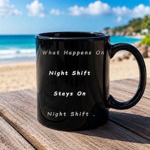 May include: A black ceramic mug with a handle, featuring white printed text that reads: What Happens On Night Shift Stays On Night Shift. The mug has a smooth, glossy finish and a cylindrical shape, designed for holding hot or cold beverages.