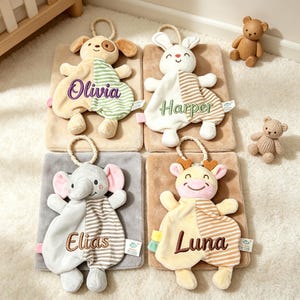Puede incluir: Cuatro mantas de seguridad para bebés con diseños de animales: un perro, un conejo, un elefante y una jirafa. Cada una tiene un nombre bordado: Olivia, Harper, Elias y Luna. También hay dos pequeños osos de peluche.