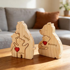 May include: Two light-colored wooden bear-shaped puzzle sculptures. The left bear features the engraved names Mummy, Daddy, and Sophia with a small red heart. The right bear features the engraved names Mummy and Liam with a small red heart.