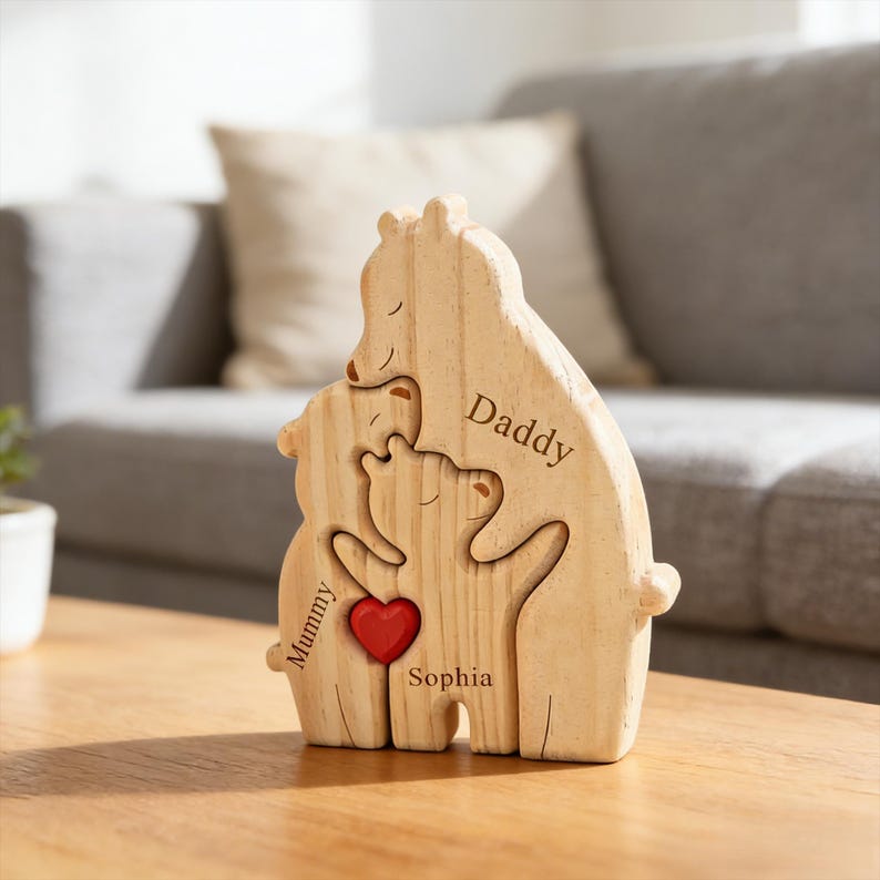 May include: A light-colored wooden bear family puzzle figurine featuring three interlocking bear shapes. The largest bear is engraved with the word Daddy, the middle bear with Mummy, and the smallest bear with Sophia. A small red heart is attached.