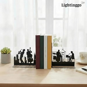 May include: Black metal bookends with a jazz band silhouette design. The bookends feature a cityscape and musicians playing instruments. The bookends are holding several books with colorful spines. The word "Lightinggo" is printed in white.