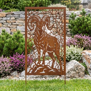 May include: A rectangular metal garden screen featuring a laser-cut design of a bighorn sheep standing on a rocky outcrop, surrounded by intricate, winding branch patterns. The metal has a weathered, rusted brown finish throughout the panel.