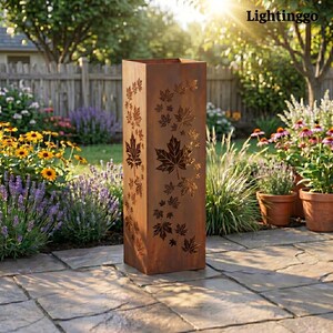 May include: A tall, rectangular, rusty brown metal planter with laser-cut maple leaf designs. The planter is outdoors on a stone patio, surrounded by flowers and greenery. The word "Lightinggo" is in the top right corner.