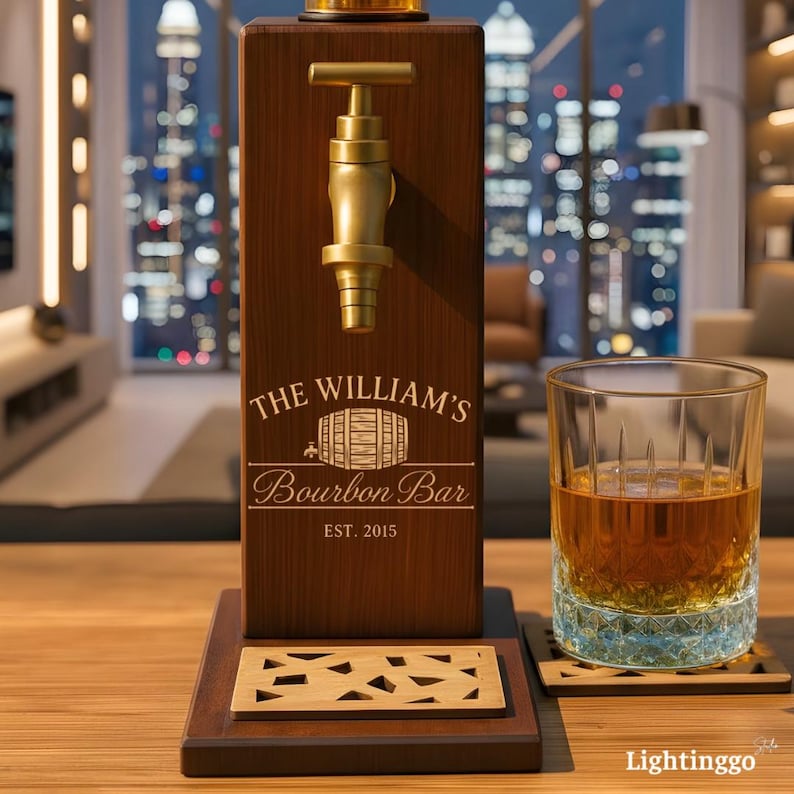 Op de afbeelding: Een houten bourbon dispenser met een messing kraan en de tekst "The William's Bourbon Bar EST. 2015." Een glas amberkleurige vloeistof staat naast de dispenser op een houten onderzetter.