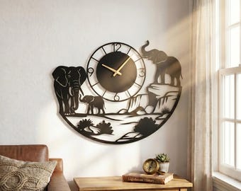 May include: Black metal wall clock featuring an elephant family silhouette. The clock has a circular face with gold-colored hands and a decorative landscape design. The clock is mounted on a white wall. The brand name "Lightinggo" is visible in the upper left corner.