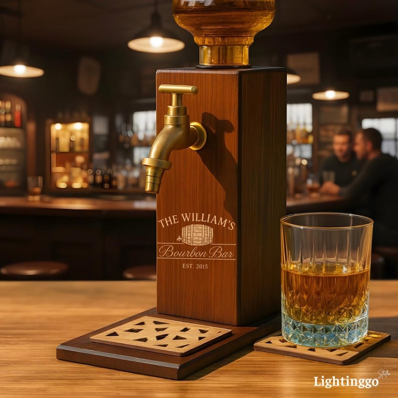 Op de afbeelding: Een houten bourbon dispenser met een messing kraan en een glas amberkleurige vloeistof. De dispenser is gegraveerd met "The William's Bourbon Bar" en "EST. 2015". Een onderzetter en een decoratieve basis zijn ook zichtbaar.