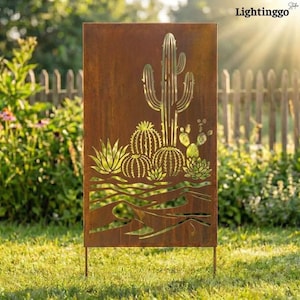 Op de afbeelding: Een rechthoekig tuinornament van verweerd metaal met een uitgesneden woestijncactusontwerp. Het kunstwerk toont verschillende cactussen en vetplanten. Het woord "Lightinggo" staat rechtsboven. Het ornament staat in het gras.