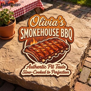May include: A decorative sign featuring a rack of ribs with flames in the background. The text reads Olivia's SMOKEHOUSE BBQ, Authentic Pit Taste, and Slow-Cooked to Perfection. The sign has a brown and orange color scheme with a die-cut shape.