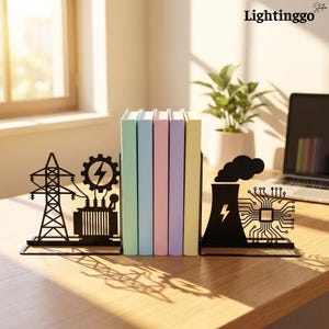May include: A pair of black metal bookends featuring industrial energy designs. One side displays an electrical transmission tower, a transformer, and a gear with a lightning bolt. The other side shows a cooling tower and a circuit board pattern.