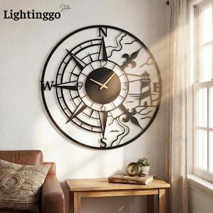 May include: A large, black metal wall clock with a compass design, featuring a lighthouse and the text "E". The clock has gold-colored hands and is mounted on a white wall. The brand name "Lightinggo" is visible in the upper left corner.
