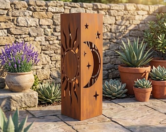 May include: A tall, rectangular, rust-coloured metal garden lantern featuring laser-cut designs of a sun on one side and a crescent moon with stars on the adjacent side. The structure has a weathered, oxidised finish and stands upright.