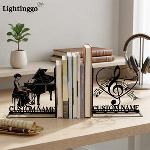 May include: Black metal bookends with a piano and musical note design. One bookend features a woman playing a grand piano, the other a heart-shaped musical note design. The text "CUSTOM NAME" is displayed on each bookend. The brand name "Lightinggo" is in the top left corner.