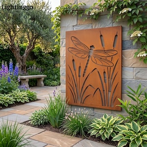 May include: A rectangular, rust-colored metal wall panel featuring a laser-cut design of a large dragonfly hovering above tall cattail reeds. The artwork is mounted on a stone wall, showcasing a weathered, oxidized finish with intricate cutouts.