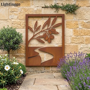 May include: A rectangular, rust-colored metal wall art piece featuring an olive branch with olives and a winding river design. The artwork is mounted on a textured stone wall, with greenery and flowers in the foreground. The brand name "Lightinggo" is in the top left corner.