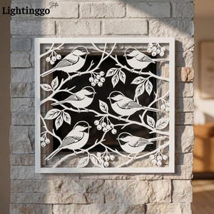 May include: A square white metal wall art panel featuring a laser-cut design of five birds perched on branches with clusters of berries. The intricate cutout pattern creates a silhouette effect against the dark background behind the frame.