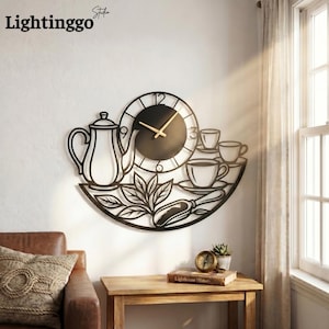 May include: Black metal wall clock featuring a teapot, teacups, and leaves design. The clock has a round face with gold-colored hands. The clock is mounted on a white wall. The brand name "Lightinggo" is in the top left corner.