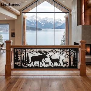 May include: A black metal railing insert featuring a laser-cut silhouette of a moose, a deer, and two fawns standing among pine trees and mountains. The rectangular panel is framed by natural wood posts and a top rail in a bright interior space.