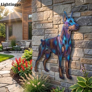 May include: A metal wall art piece shaped like a Doberman Pinscher dog, featuring a heat-treated finish with iridescent blue, purple, and bronze tones. The silhouette is mounted on a stone wall, displaying cut-out details along the body.