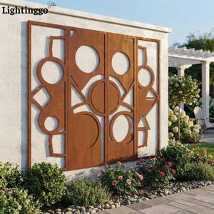 May include: A large, rectangular, rust-colored metal wall panel featuring a geometric cutout design with various circles and angular shapes. The panel is mounted on a white exterior wall, displaying a weathered, oxidized finish throughout.