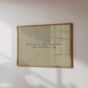 Può includere: Un quadro rettangolare con uno sfondo testurizzato color beige chiaro, racchiuso in una sottile cornice di legno. Il testo "the peace of God surpasses all understanding" è stampato al centro in un carattere corsivo di colore nero.