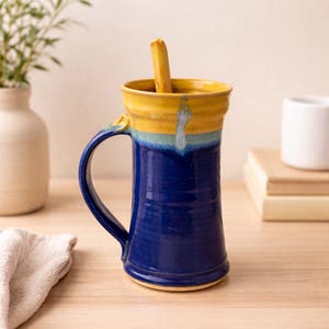 Puede incluir: Un letrero de madera hecho a mano con la palabra "Welcome" en una fuente juguetona. El letrero está pintado de blanco con un acabado envejecido y presenta un diseño floral decorativo en tonos de rosa y verde. Diseñado para colgar en una puerta o pared.