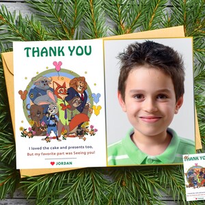 Puede incluir: Una tarjeta de agradecimiento con una ilustraci&oacute;n de dibujos animados de personajes de Zootopia y el texto "THANK YOU" en verde. La tarjeta tambi&eacute;n incluye una foto de un ni&ntilde;o sonriente. El texto dice: "&iexcl;Tambi&eacute;n me encantaron el pastel y los regalos, pero mi parte favorita fue verte!" y el nombre "JORDAN".