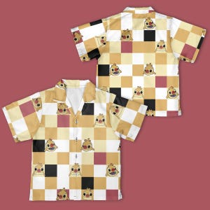 Pu&ograve; includere: Camicia a maniche corte con bottoni e motivo ripetuto di personaggi dei cartoni animati su sfondo a scacchi. Il design della camicia incorpora quadrati gialli, bianchi, neri e marroni. Il personaggio dei cartoni animati ha un corpo giallo e un volto sorridente.